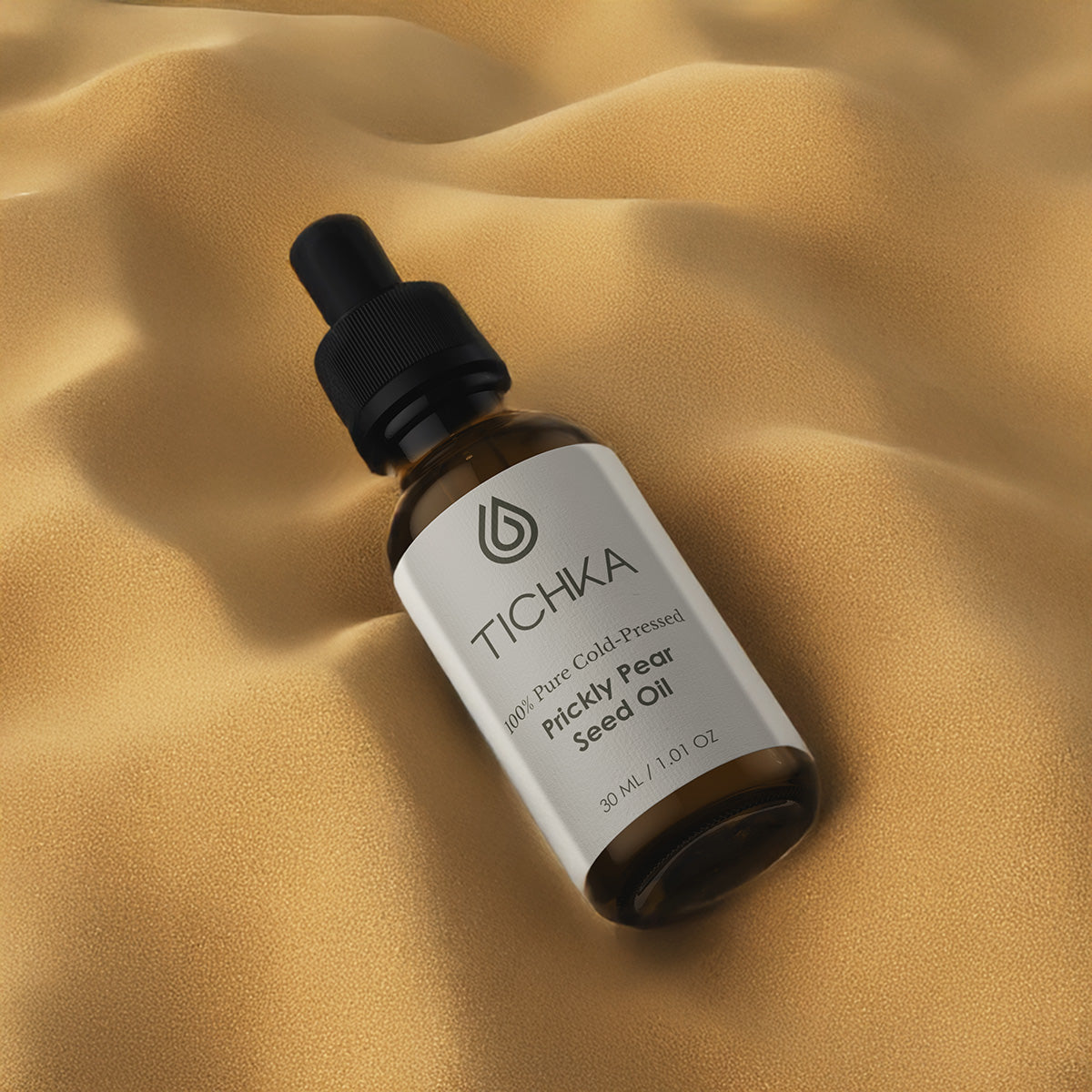 TICHKA bottle of prickly pear seed oil on a beige fabric background