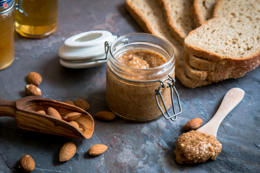Crucnhy Amlou in a jar with almonds and bread beside it