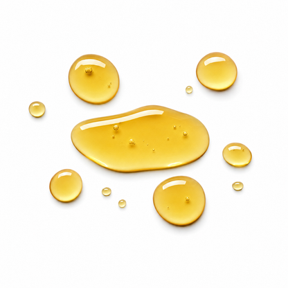 Golden translucent honey droplets and a larger pool on a clean white background.