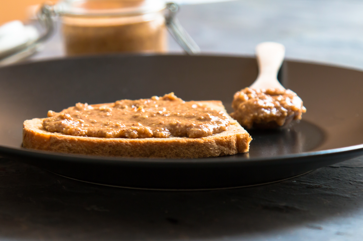 Slice of bread on a plate with amlou and spoon